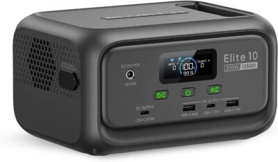 BLUETTI Elite 10 Mini portable power station sitting on an airplane tray table charging a laptop and a smartphone