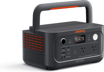 Jackery Explorer 500 v2 portable power station with solar panels in a forest camping setting