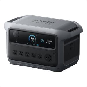 Anker SOLIX C2000 Gen 2 portable power station powering a coffee maker and a laptop at a scenic forest campsite.