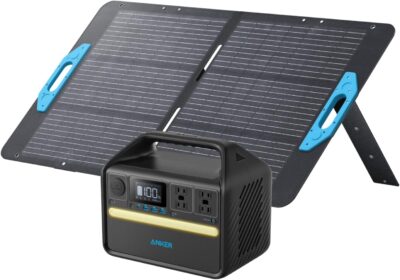 Anker 535 Solar Generator Powerhouse sitting on a wooden camp table with its 100W foldable solar panel facing the sun in a forest setting