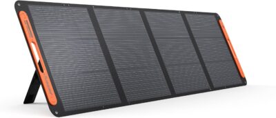 Jackery SolarSaga 200W Bifacial portable solar panel unfolded on a sunny beach, charging a Jackery Explorer power station