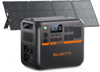BLUETTI AC200PL solar generator with 200W solar panel set up next to a modern RV camper in the woods