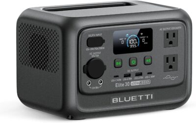 BLUETTI Elite 30 V2 portable power station sitting on a wooden table powering a laptop and a desk lamp during a home power outage.