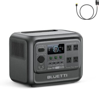 BLUETTI Elite 100 V2 portable power station sitting on a wooden camping table next to a coffee mug outdoors