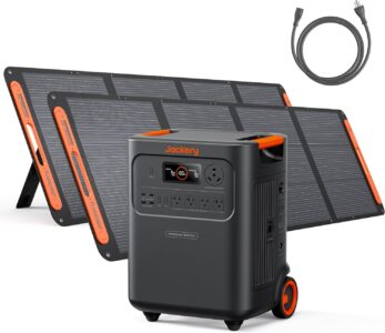 Jackery HomePower 3600 Plus portable power station with two 200W solar panels set up next to an RV in a sunny forest clearing.