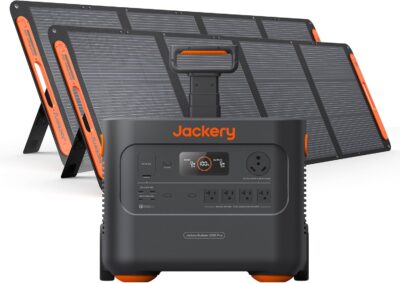 Jackery Solar Generator 2000 Plus with 400W solar panels set up next to a modern RV in a sunny forest clearing